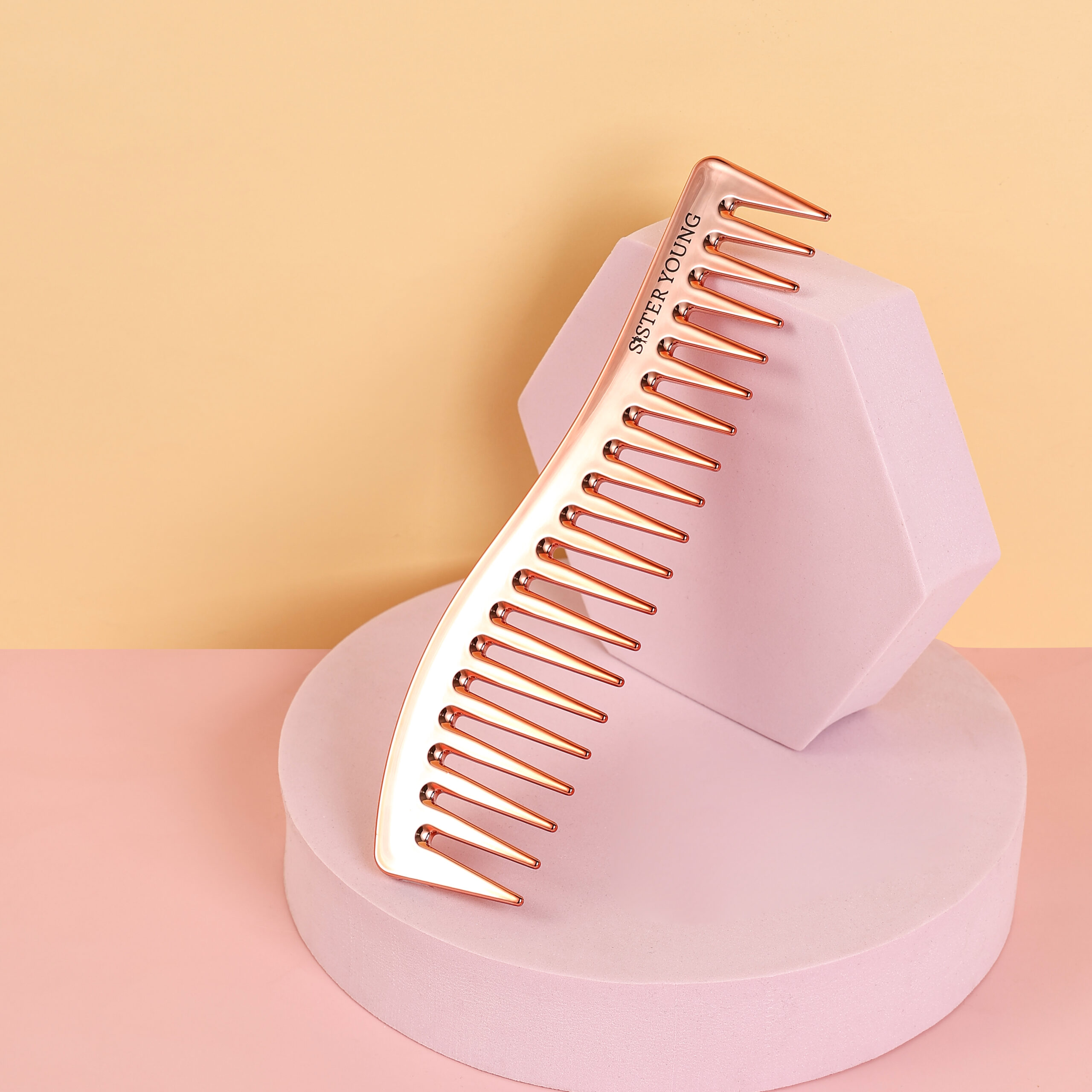 Grzebień Zuri Rose Gold w kolorze różowego złota oparty na różowej podstawce