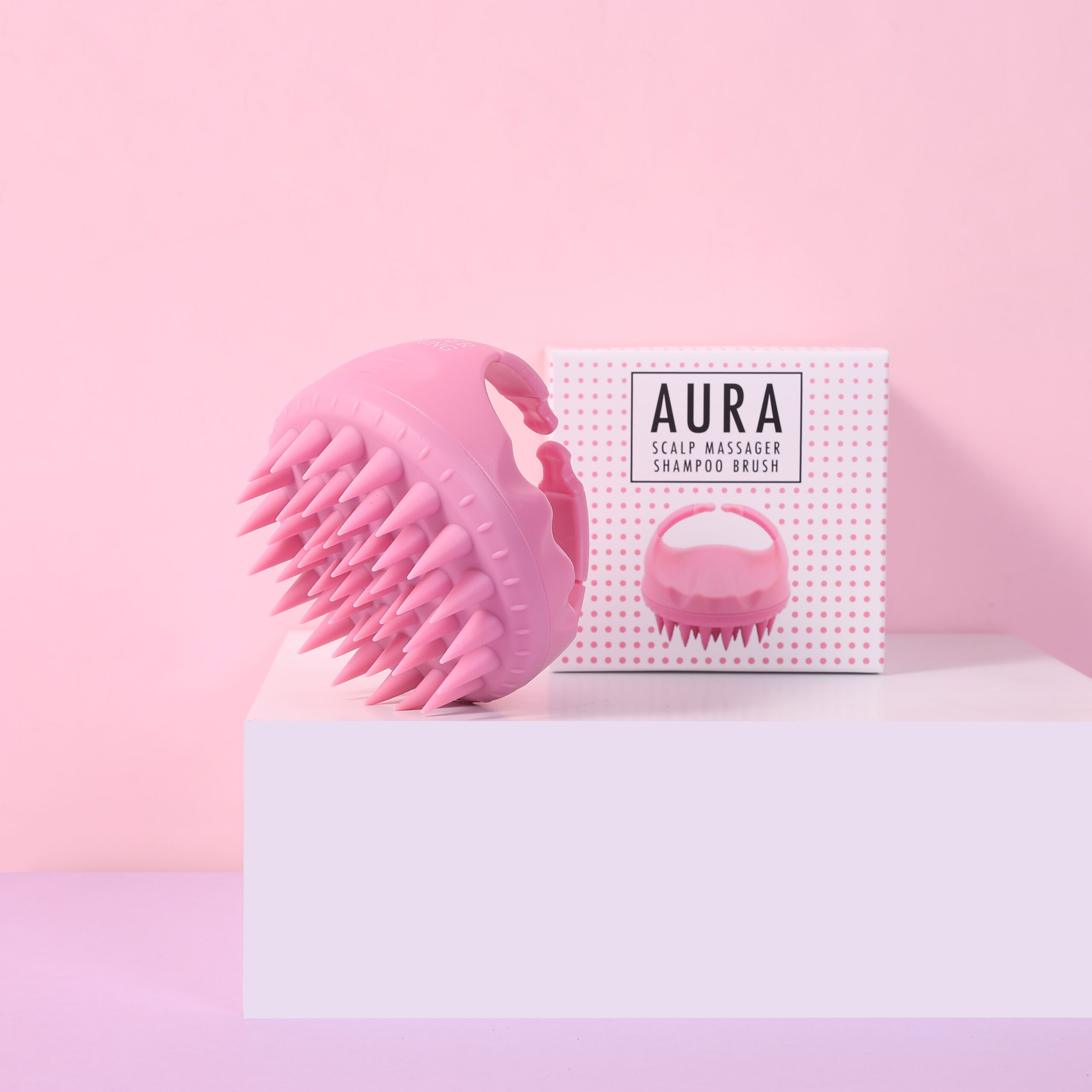 Szczotka Sister Young AURA Pink i jej opakowanie na jasnym podeście, na różowym tle.