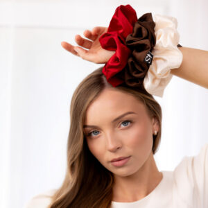 Modelka z ręką uniesioną nad głową i gumkami Sister Young LILU Cherry Red, Chocolate Coffee i Ice Cream na nadgarstku.