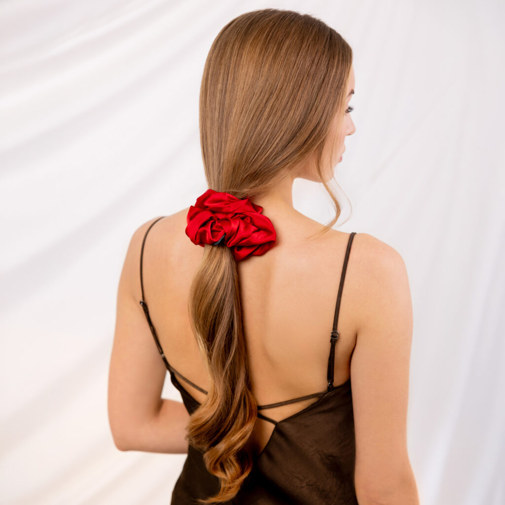 Długie włosy modelki związane w kucyk ciemnobrązową gumką Sister Young LILU Cherry Red, widok z tyłu.