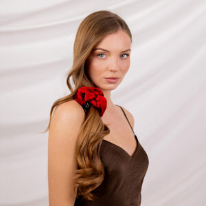 Modelka spoglądająca przez ramię, z włosami związanymi w kucyk czerwoną gumką Sister Young LILU Cherry Red.