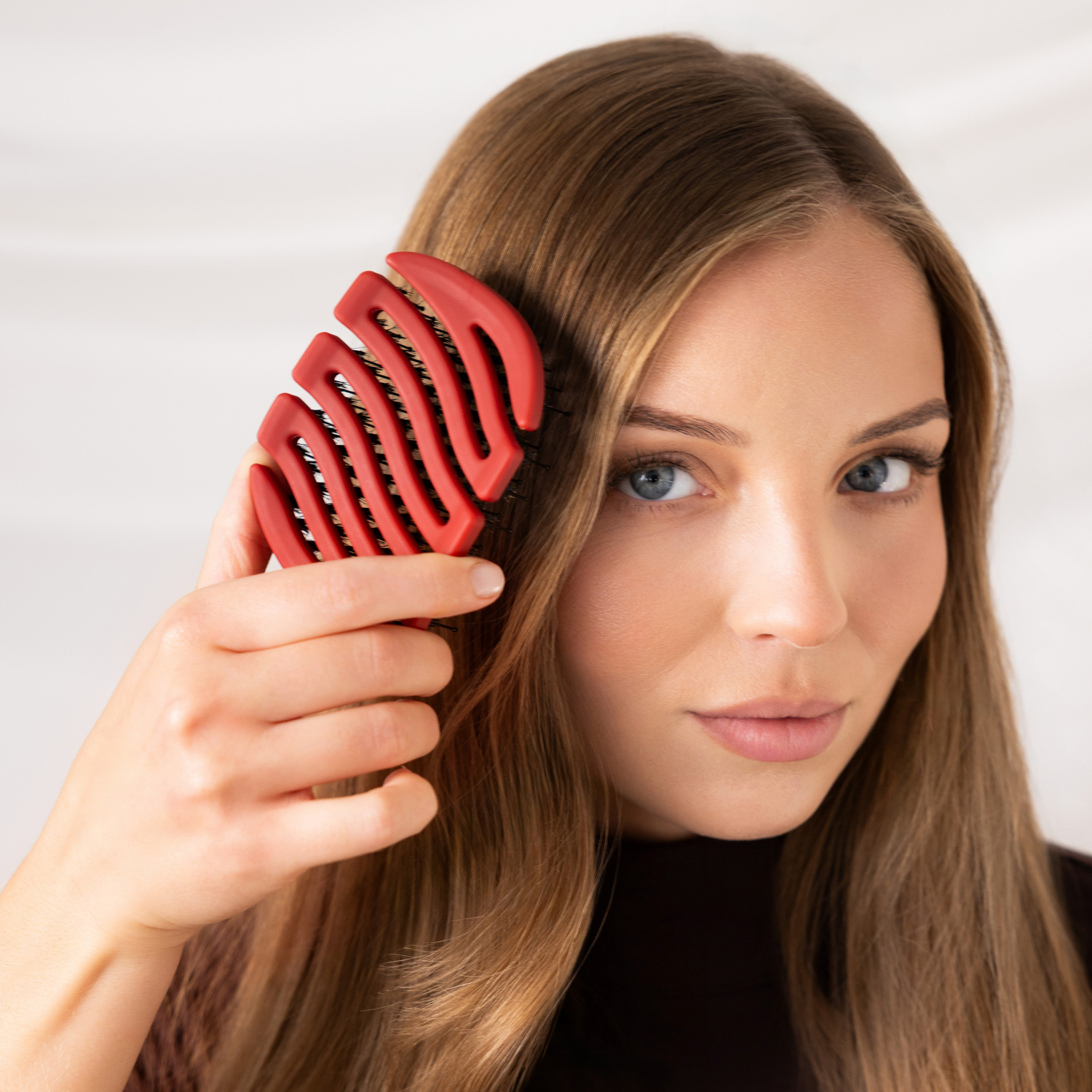 Modelka czesząca włosy przy twarzy czerwoną szczotką Sister Young MILA Cherry Red.