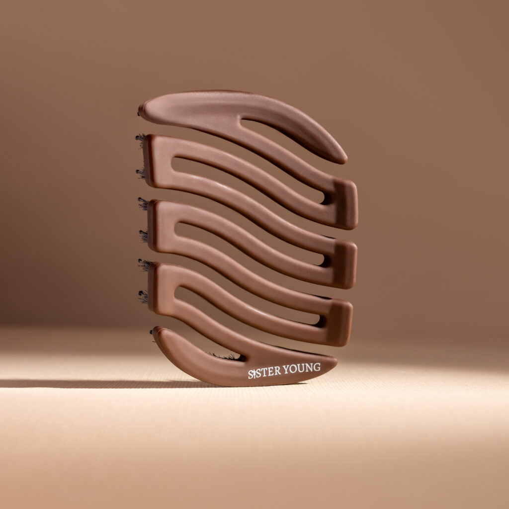 Tył mini szczotki Sister Young MILA Chocolate Coffee ustawionej pionowo na podwyższeniu, na brązowym tle.